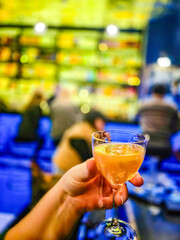 hand holding a glass of cocktail at a bar