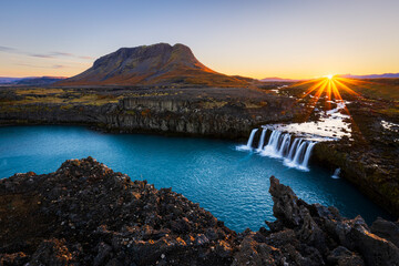 Fototapeta premium Mount Burfell and Þjófafoss (Thjofafoss) waterfall at sunrise located on the river Thjorsa in the south of Iceland.