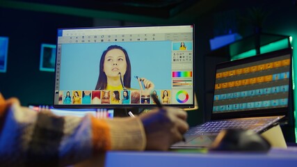 Male graphic artist using essential digital tools on dual monitors, professional design work...