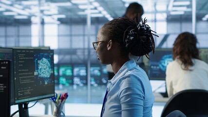Portrait of happy computer scientist programming in AI data center used for machine learning...
