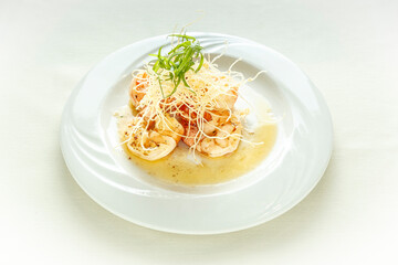 A plate of food with shrimp and a sauce on top