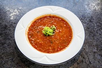 A bowl of soup with a green garnish on top