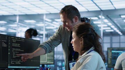Woman requesting help from senior engineer to fix error in high tech AI data center. Employee in need of aid from IT professional to repair artificial intelligence supercomputers, camera A