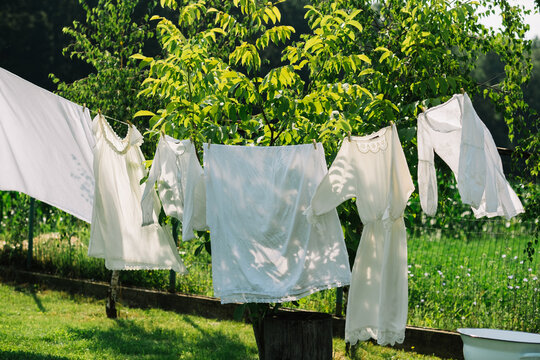 Clean white clothes on a washing line in a backyard