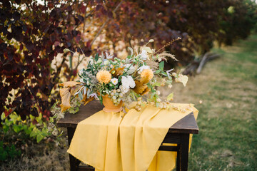 Floral display in earthy tones on wooden table.