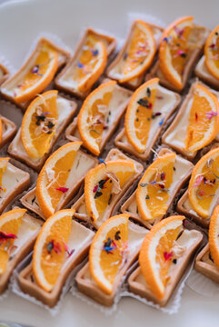 Close-up of orange-flavored mini tartlets on a plate.