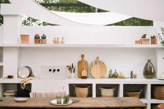 Rustic outdoor kitchen with shelves and wooden decor.