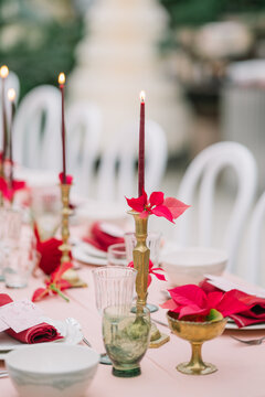 Elegant table setup with candles and poinsettias decor.