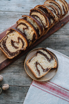 Chocolate swirl bread and slice on plate with nuts