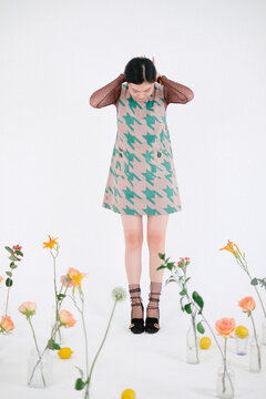 Woman Standing Next to Flowers and Lemons