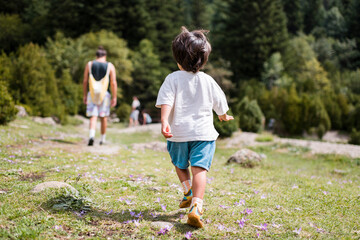 Confident toddler following father at the mountain
