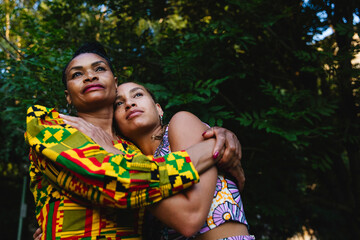 Mother and daughter embracing with thoughtful expressions in tra