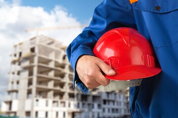 Fototapeta premium Safety workwear hold safety helmet at construction