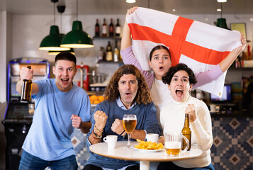 Group of happy people with England flag toasting with beer, having fun at party in nightclub