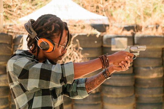 African man Shooting guns at gun range
