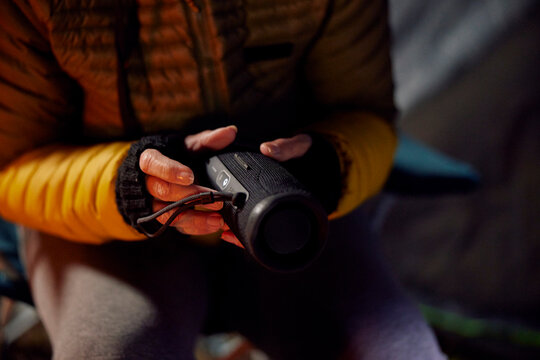 Close up of a camper holding a portable speaker