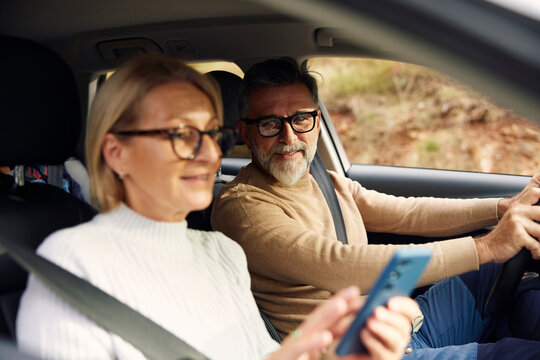 Man and a woman are traveling by car