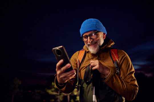Smiling hiker checking his phone