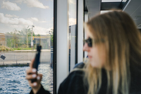 A young woman taking photo on a public ferry