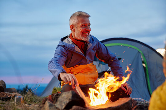 Man makes a bonfire at the campsite
