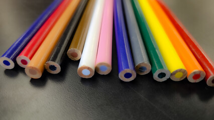 abstract closeup of colored pencils on black desk smooth texture background