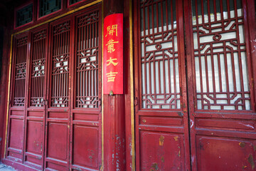 The words "good luck for opening" on the column of huixianju shop in Suzhou street of the summer palace in Beijing.