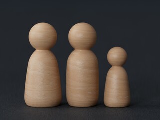 wooden family peg dolls for protection with copy space. Family protection and insurance coverage concept. The insurance agent presents protection model that symbolize the coverage.