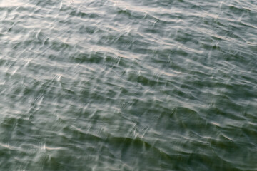 A close-up of rippling water with a subtle blue-green hue. Perfect for backgrounds or to evoke a sense of tranquility and nature