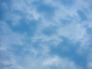 A cloudy sky with a mix of white and gray clouds, creates a dramatic and moody atmosphere