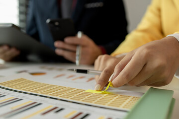 Businessman brainstorming to find strategies to increase revenue for the company. Two coworkers are...