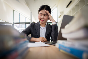 Portrait of tired young business Asian woman work with documents tax laptop computer. Sad, unhappy, Worried, Depression, or employee life stress sad concept