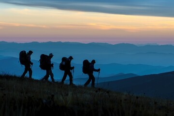 Four Hikers Silhouetted Against a Multi-Layered Mountain Range at Sunset