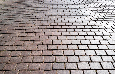Stone road. Pavement texture. Stonework background for design. Granite cobblestoned pavement background. Abstract background of cobblestone pavement.