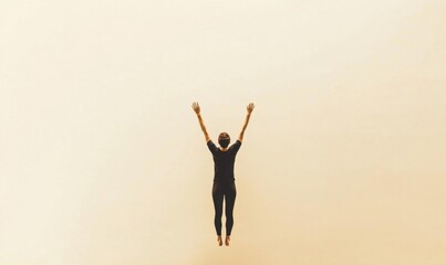 Fototapeta premium A person jumps joyfully against a soft, light background.