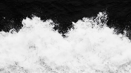 Monochrome close-up of churning white water against a dark background.