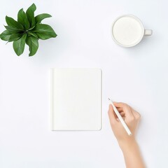 Obraz premium A serene workspace featuring a hand holding a pen, a blank notebook, a cup of milk, and a potted plant against a minimalistic background.