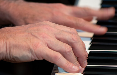 hands of a person playing the piano