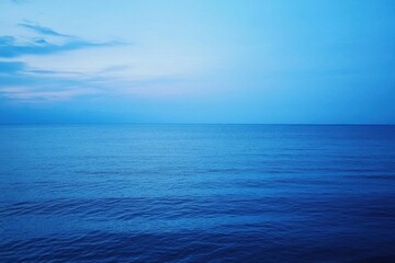 Obraz premium Tranquil ocean view under a serene blue sky at dusk.