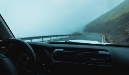 Obraz premium Driving offroad car on foggy raining high elevation mountains