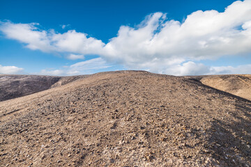 Desert gravel sand platform and sky clouds natural landscape under blue sky. Outdoor natural background.
