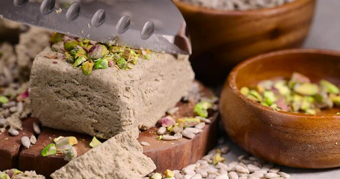 halva from roasted sunflower seeds closeup with pistachios, a sweet delicious dessert made from fried sunflower seeds, wooden bowl
