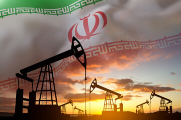 Silhouette of oil pumps against the sunset with flag of Iran. Iran Oil Industry concept. Crude oil...