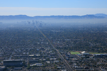 Air pollution from Interstate-10 and I-17 in morning haze above major Arizona city downtown of Phoenix as seen from the top of North Mountain Park hiking trails