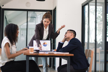 Team of professional Asian businessmen meeting to discuss data charts and graphs during meeting in modern office