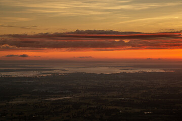 Orange-red sky and clouds over the lake before the sun rises in early morning. Natural landscape