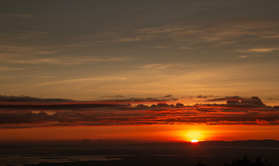 The sun rises in the morning with red sky and clouds. Natural landscape and sunrise at skyline.
