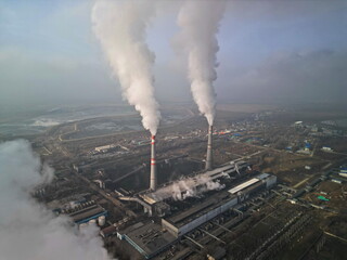 Thermal power plant. Active smoke from pipes and cooling towers. The view from the drone.