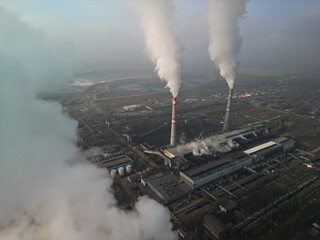 Thermal power plant. Active smoke from pipes and cooling towers. The view from the drone.