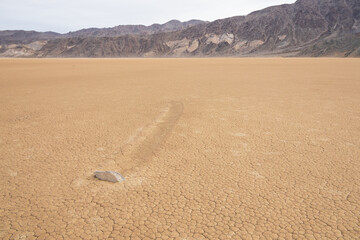 Moving rocks in the dry lake bed at The Racetrack at Death Valley National Park, California