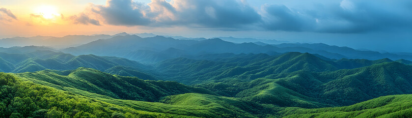Obraz premium Sunset over rolling green hills and mountains.